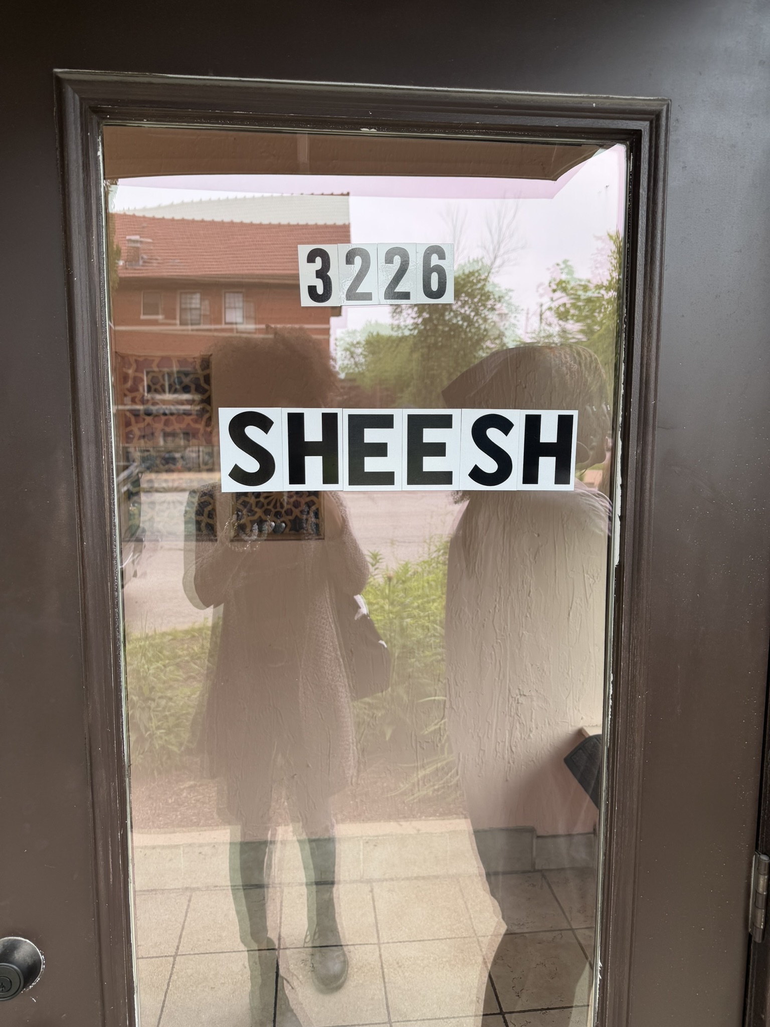 Reflection of Kobe and I in front of a door.